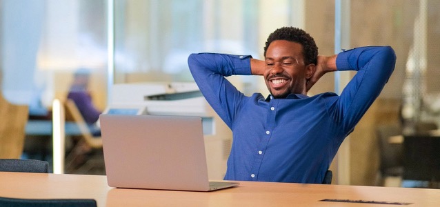 man reclining in office and smiling