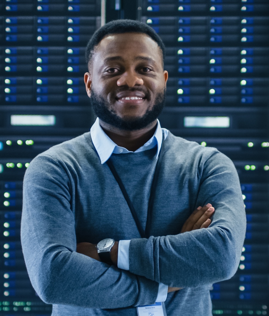 Man smiling in front of a rack of servers