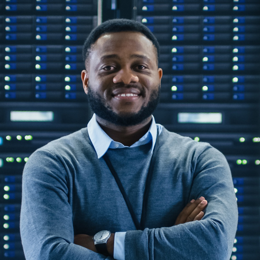 Man smiling in front of a rack of servers